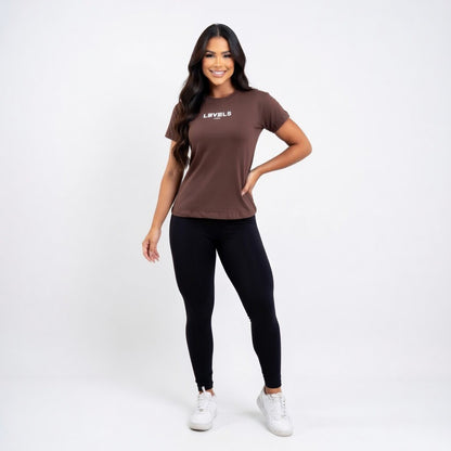 Woman wearing a brown t-shirt and black leggings on a white background